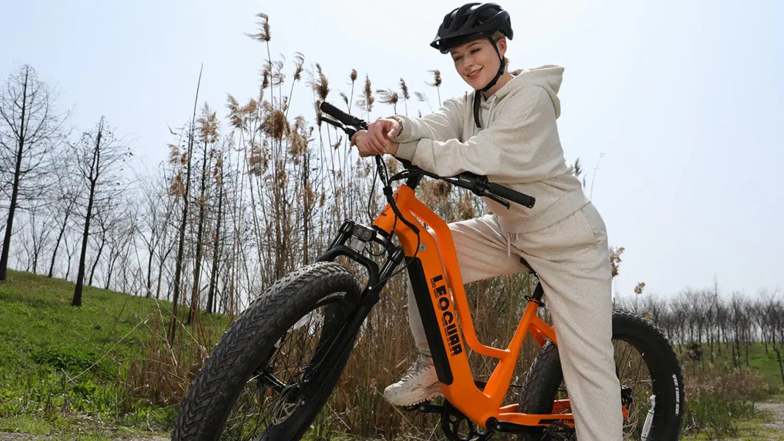 Rider enjoying off-road adventure with a fat tire Leoguar electric bike and helmet