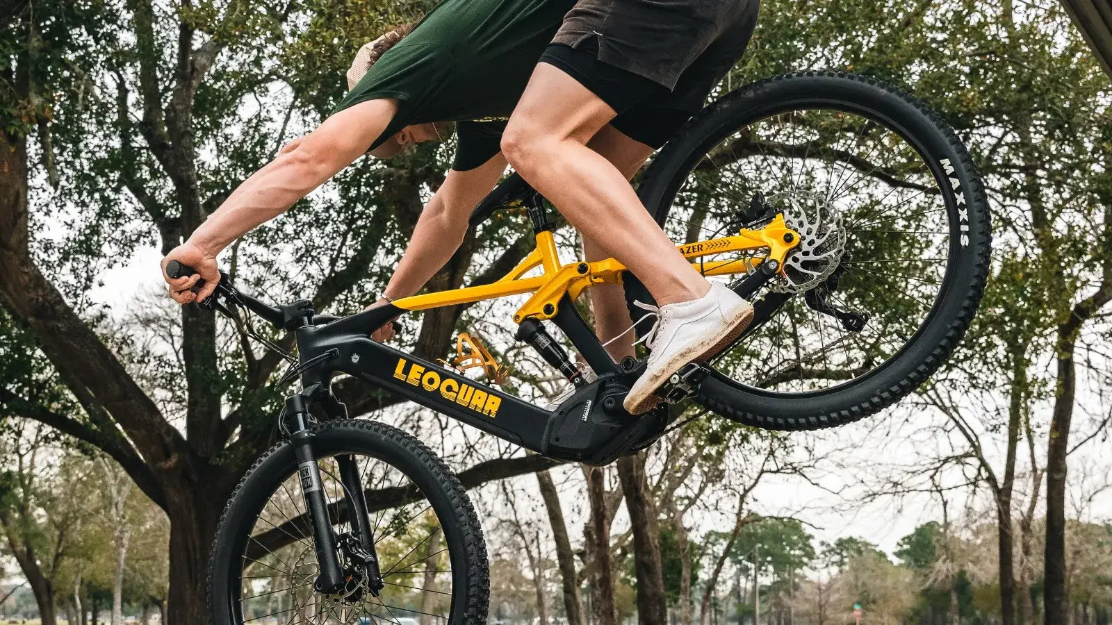 Off road electric mountain bike in action performing a jump in a park setting.