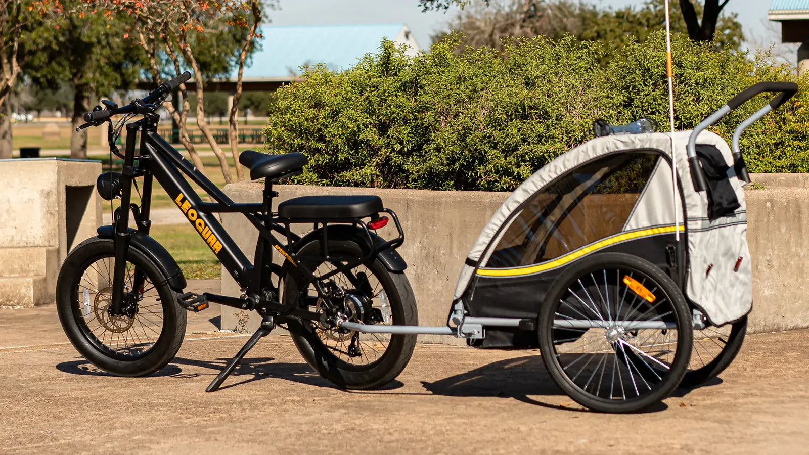 Electric cargo bike with eco trailer parked under the sun, showcasing sustainable transport options for families and gear.
