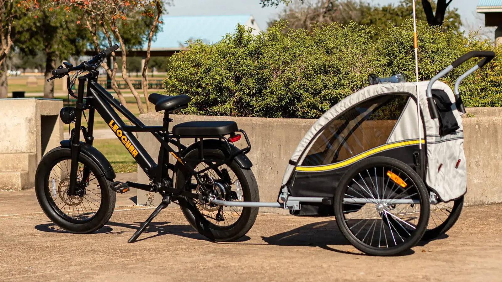 Electric cargo bike with eco trailer parked under the sun, showcasing sustainable transport options for families and gear.