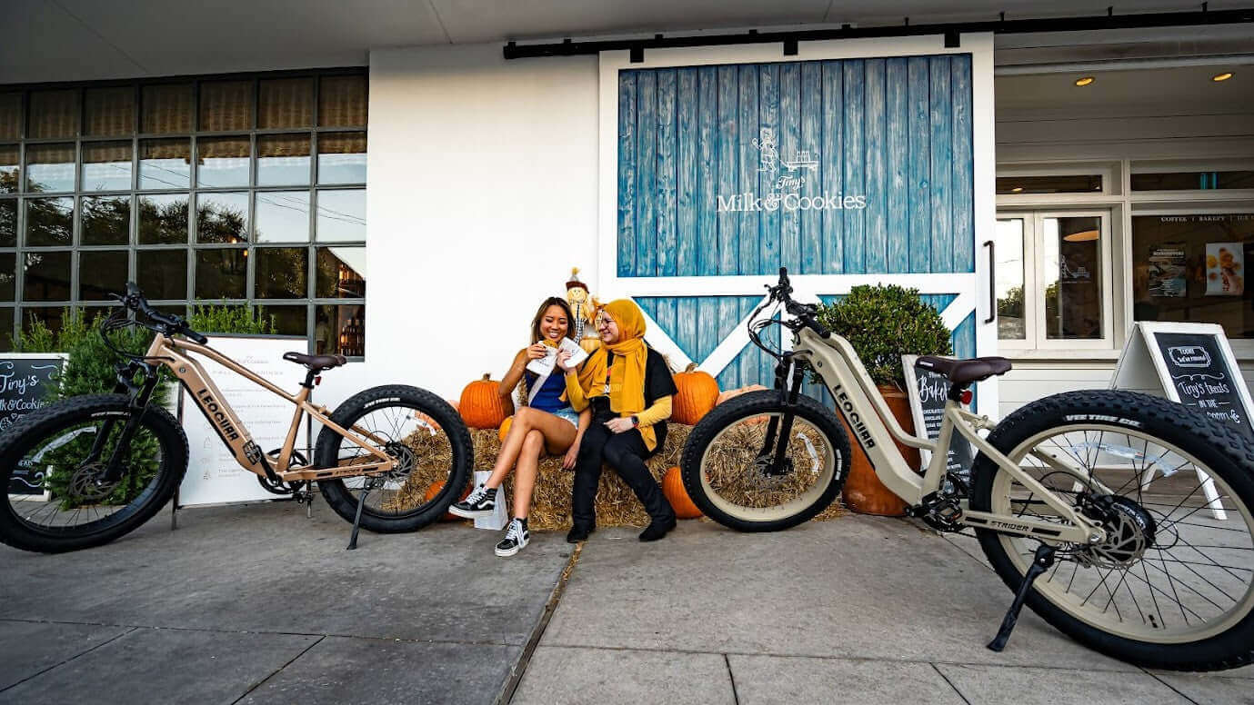 Two people enjoying time together near electric bikes outside a shop, highlighting electric bike key replacement.