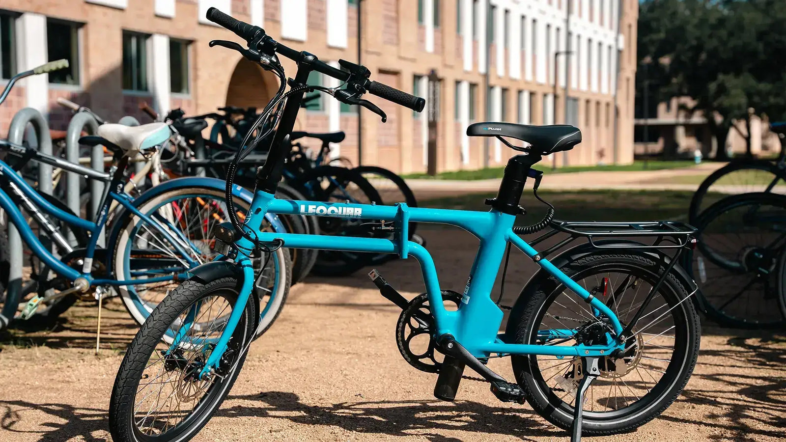 Rear mounted bike rack for e-bike on a blue electric bike parked among other bicycles.