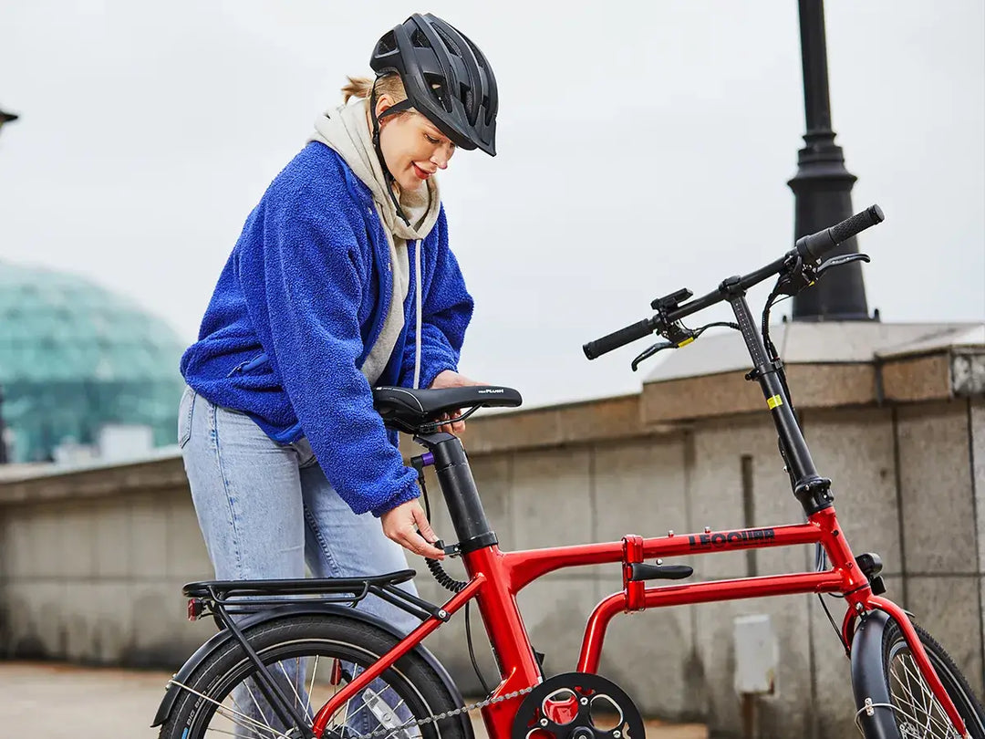 Woman adjusting seat on red Flippo ebike